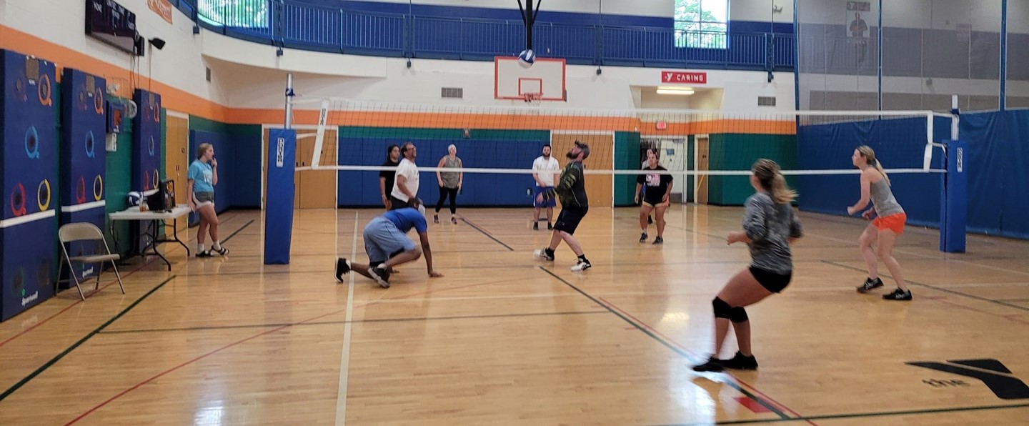 adults playing indoor volleyball