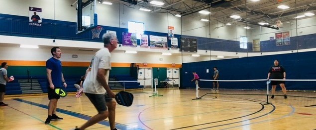 people playing pickleball in gym