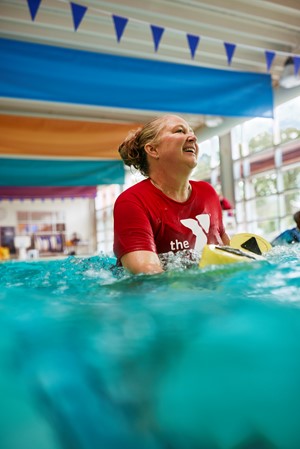 woman in pool with hand weights